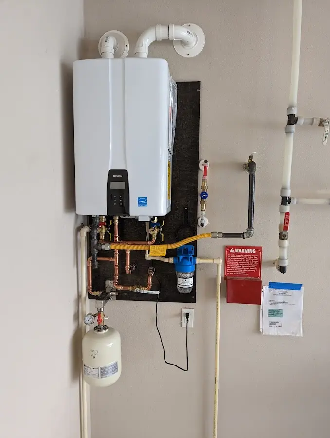 Professional plumber installing copper piping in a Whitman home